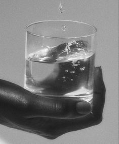 a hand holding a glass filled with water