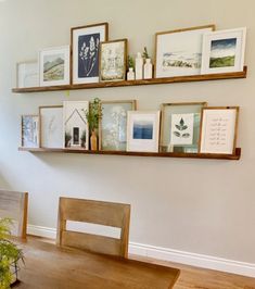 a dining room table with some pictures on the wall