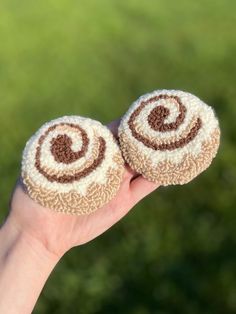 two small brown and white objects in someone's hand