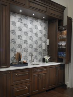 a kitchen with wooden cabinets and white counter tops, along with a wallpapered backsplash