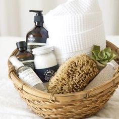 a wicker basket filled with personal care items on top of a white bed sheet