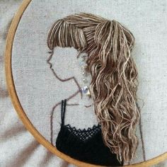 a woman's head is shown through a hoop on a white surface with fabric