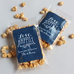 two bags of popcorn sitting next to each other on a white counter top with scattered kernels around them