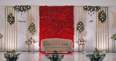 the stage is decorated with red flowers and greenery