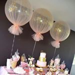 a table topped with lots of balloons and cake