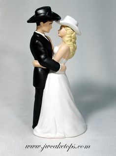 a bride and groom figurine standing next to each other