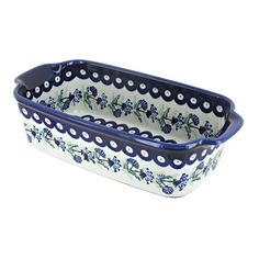 a blue and white rectangular dish with flowers on the rim, sitting on a white surface