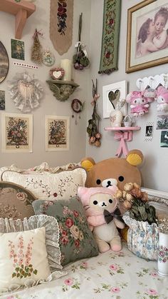 a teddy bear sitting on top of a bed in a room filled with pictures and other items