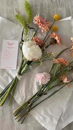 flowers are laid out on top of white paper and placed on the ground next to each other