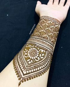 a woman's hand with henna tattoos on her left arm and the wrist