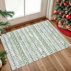 a green and white rug sitting on top of a wooden floor next to a christmas tree