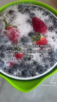 a green bowl filled with water and berries