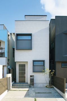 the house is white and has black shutters on each side, along with brown doors