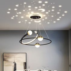 a dining room table and chairs with lights hanging from it's ceiling above them