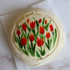 there are three pizzas that have been decorated with red flowers on them and green leaves