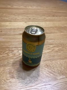 a can of beer sitting on top of a wooden table