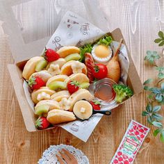 an open box filled with fruit on top of a wooden table next to other items