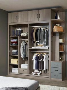 an open closet with clothes and shoes on the shelves, next to a white bed