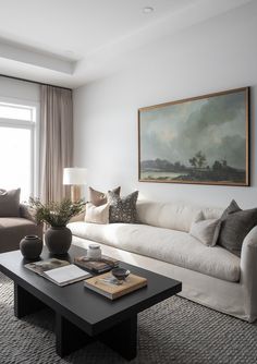 a living room filled with furniture and a large painting on the wall above the couch