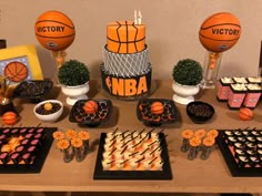 a table topped with cakes and desserts covered in basketball decorations