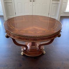 an oval dining table with gold trimmings on the top and bottom, sitting in front of a white door