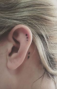 a woman's ear with small black dots on it