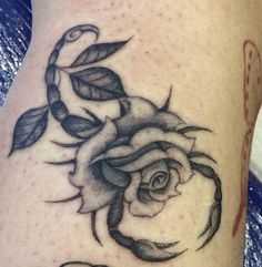 a black and white rose tattoo on the thigh