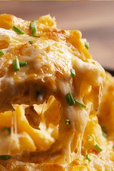 a fork full of cheesy pasta with cheese and green onions