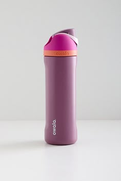 a purple and pink water bottle sitting on top of a white table