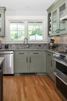 a clean kitchen with stainless steel appliances and wood flooring is seen in this image