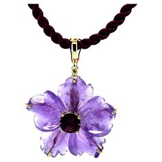 This beautifully carved amethyst flower pendant is so pretty and fun! A single amethyst crystal has been hand carved into a five petaled flower with lovely 3 dimensional curves and a soft, detailed outline. Set in the middle of the flower is a brilliant purplish pink mulberry garnet. This pendant doubles as a pearl / bead enhancer with the back of the bail opening on a hinge. So versatile and unique! Handcrafted in 18k yellow gold by our Master Jewelers in Los Angeles. A creative way to add ever Amethyst Flower, Garnet Pendant, Rhodolite Garnet, Flower Pendant, Amethyst Crystal, So Pretty, Pearl Beads, Garnet, Hand Carved