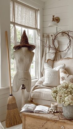 a room filled with furniture and a broom on top of a wooden table in front of a window