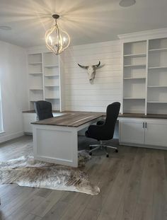 an empty office with cow hide rugs on the floor and shelves in front of it