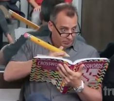 a man reading a book while holding a baseball bat