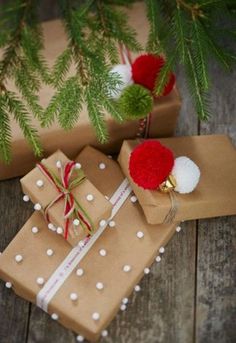 presents wrapped in brown paper with red and white pom - poms on them