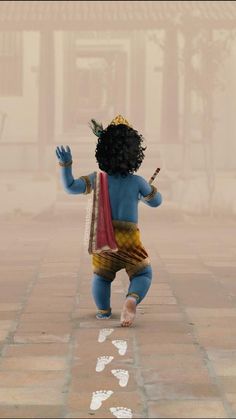 a small child dressed in blue and yellow is standing on the sidewalk with his hands up