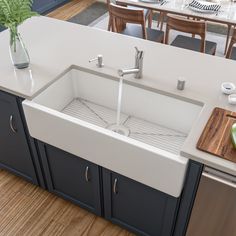 a white kitchen sink sitting under a faucet next to a wooden cutting board