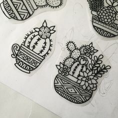 four stickers with designs on them sitting on top of a white table next to each other