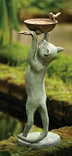 a statue of a cat carrying a bowl on its back