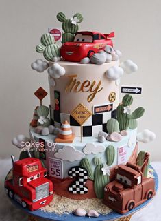 a three tiered cake with cars and trucks on it