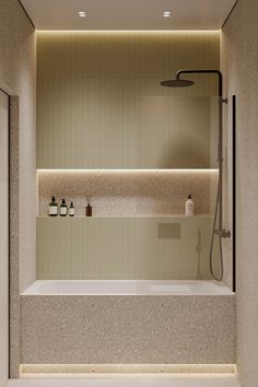 a bathroom with a bathtub, shower head and shelves on the wall next to it