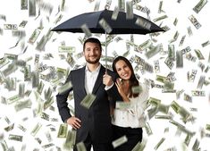 a man and woman under an umbrella with money falling around them in the air behind them