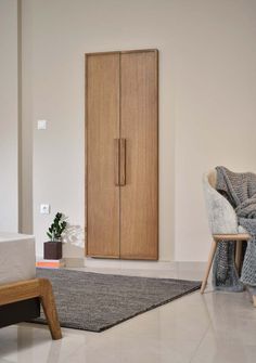 a living room with a couch, chair and wooden cabinet in the middle of it