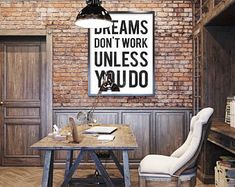 a room with a brick wall and a wooden table in front of it, which reads dream don't work unless you do