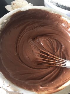 a mixing bowl filled with chocolate and whisk