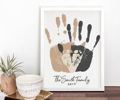 the family handprint is displayed in front of a potted plant on a table