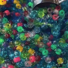 there are many different colored beads in the bins and one is being filled with them