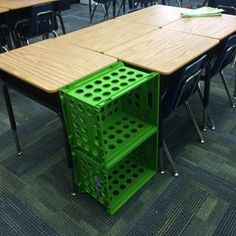 an empty classroom with several tables and chairs around it, all made out of green plastic crates