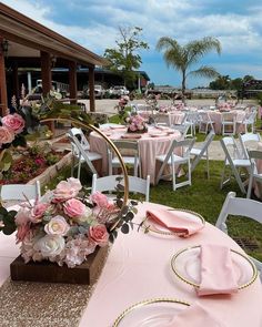 tables set up with pink and white flowers on them for an outdoor wedding or reception