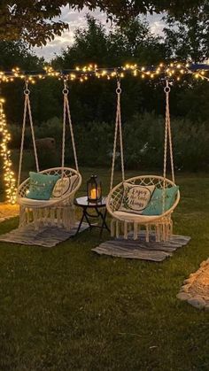 two chairs and a table are set up in the yard with lights strung across them